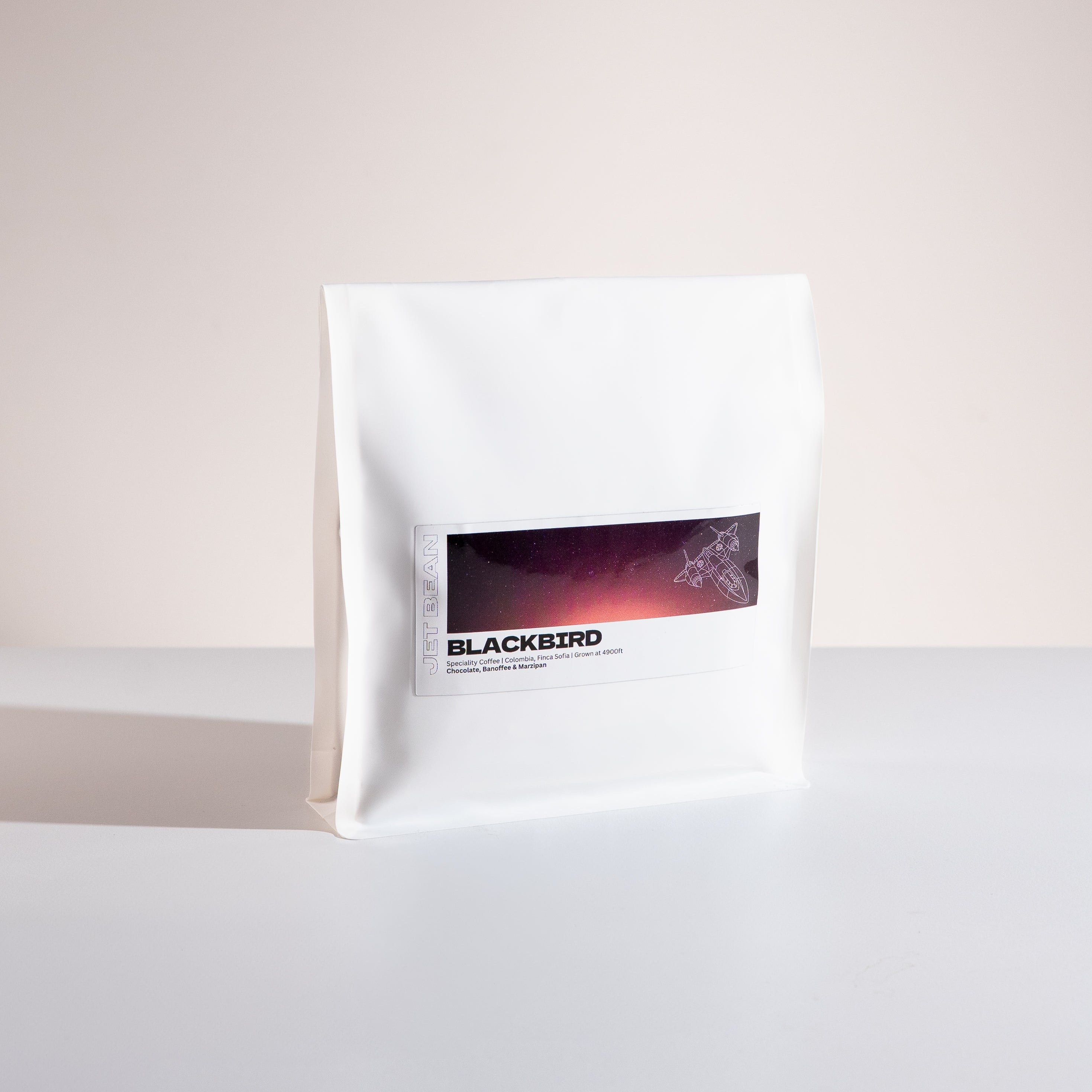 White coffee bag with 'Blackbird' branding on a light gray background