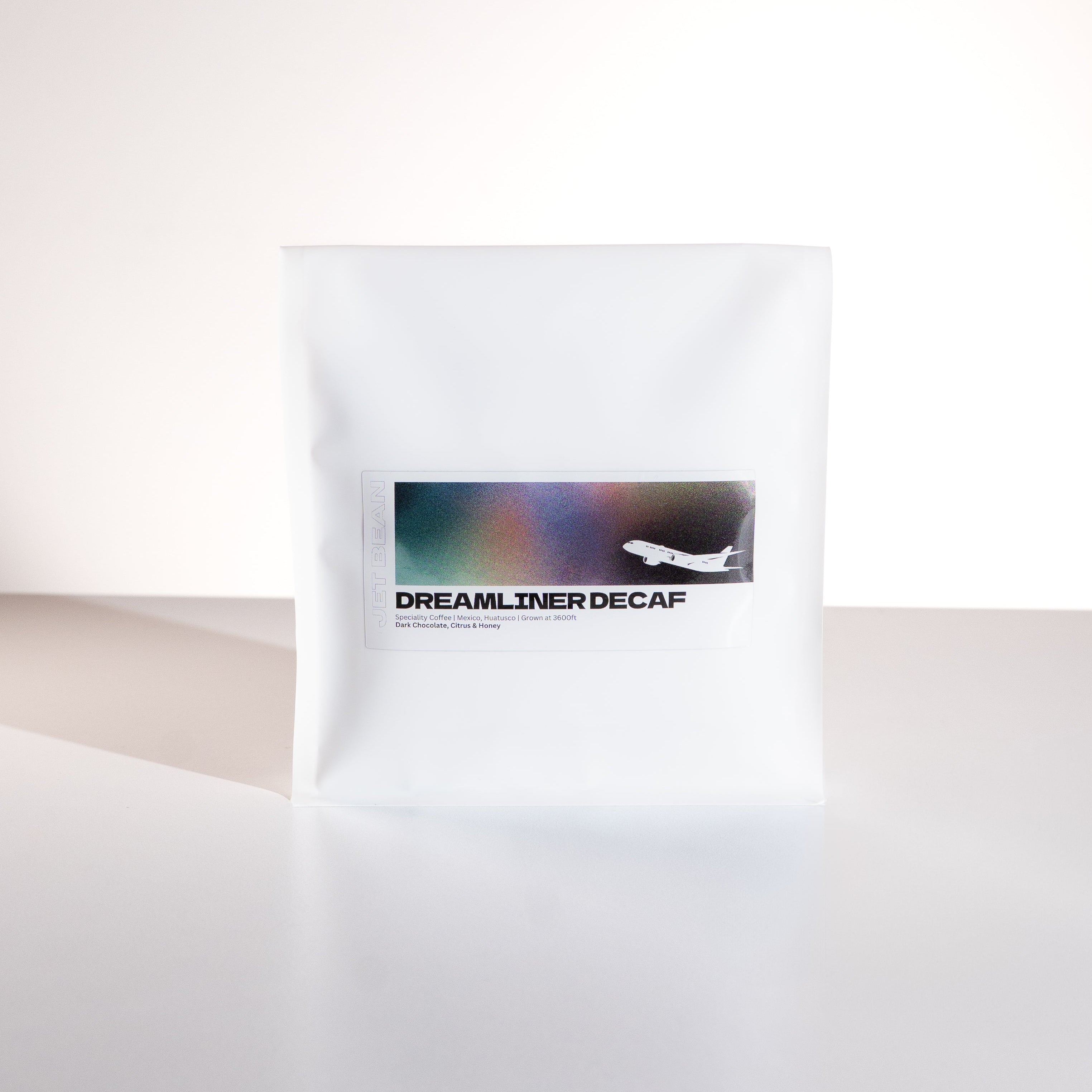 White coffee bag labeled 'Dreamliner Decaf' on a white background