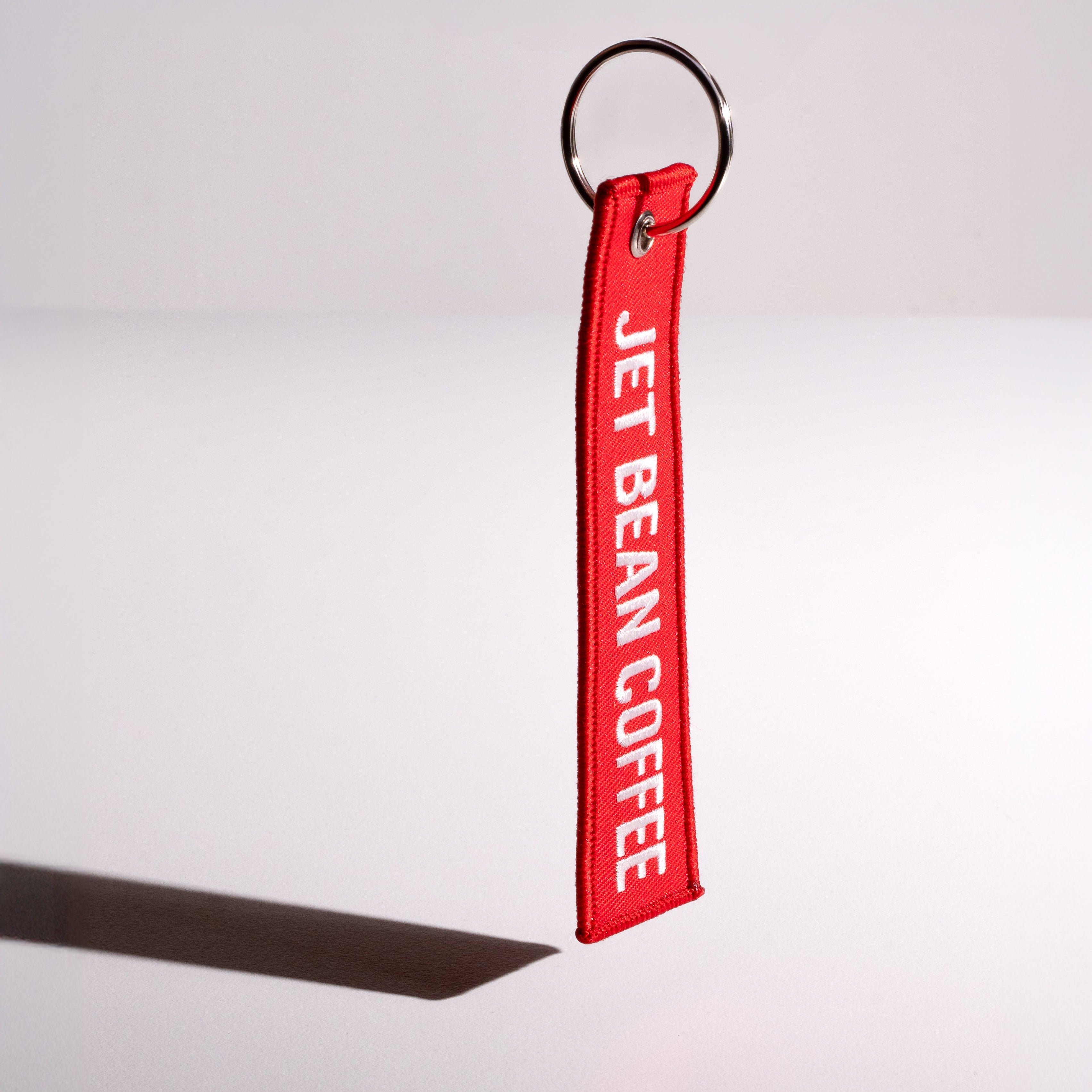 Red keychain with 'Jet Bean Coffee' text on a white background