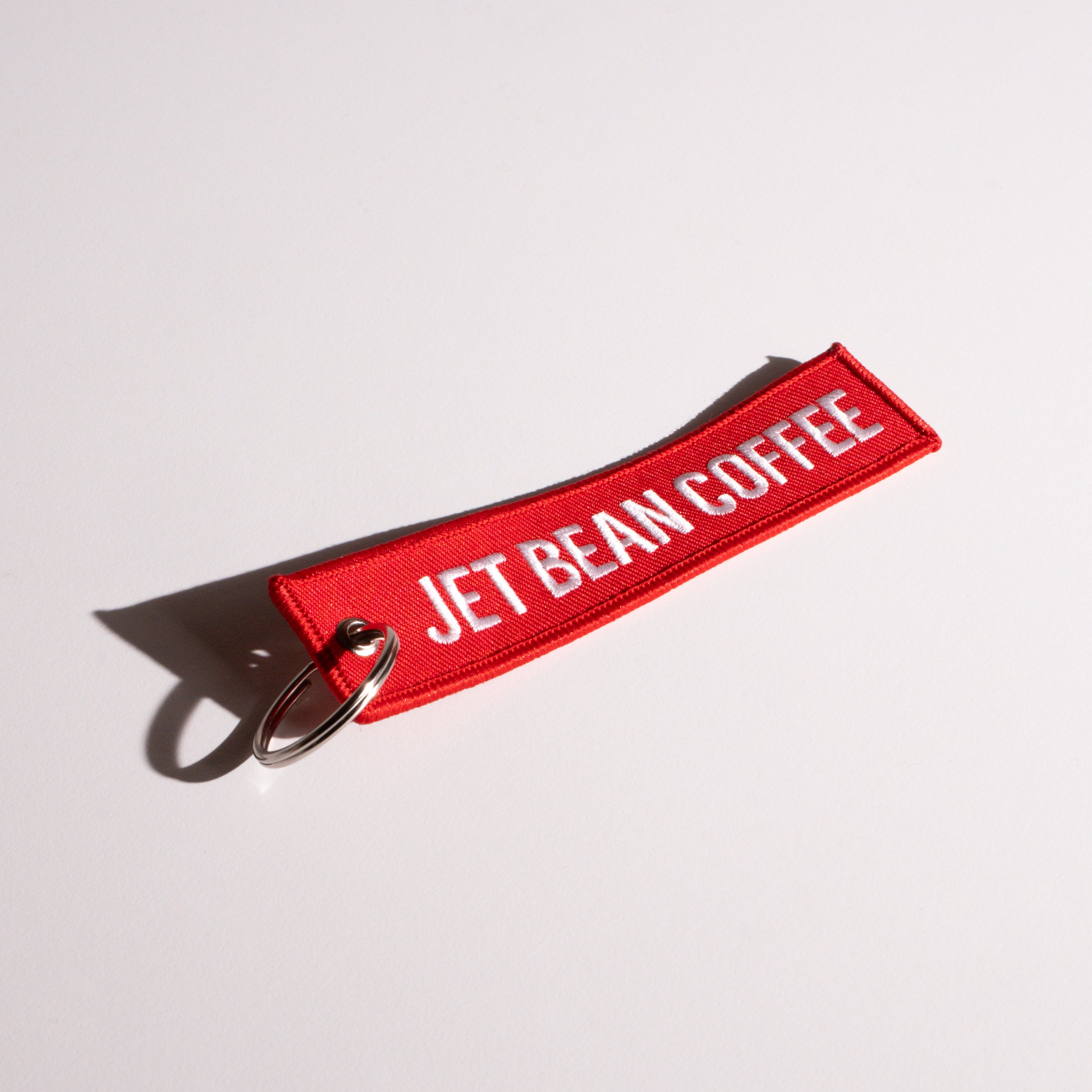 Red keychain with 'Jet Bean Coffee' text on a white background